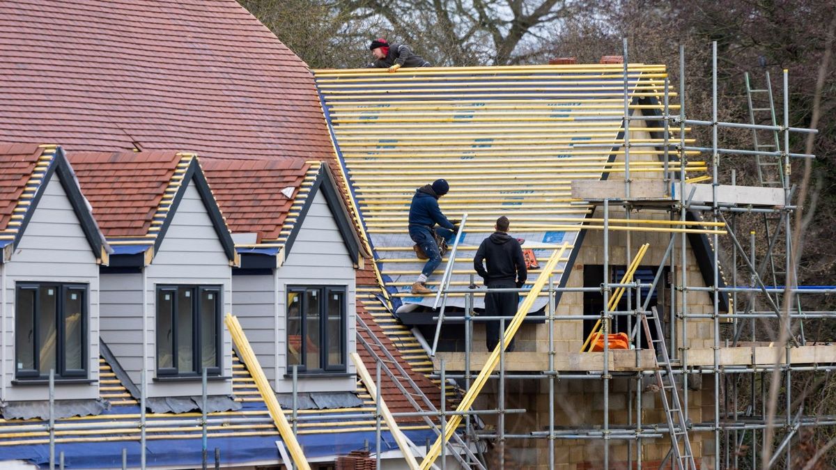 Buildings being constructed with roof tiles being laid