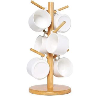 A wooden mug tree with white mugs on it