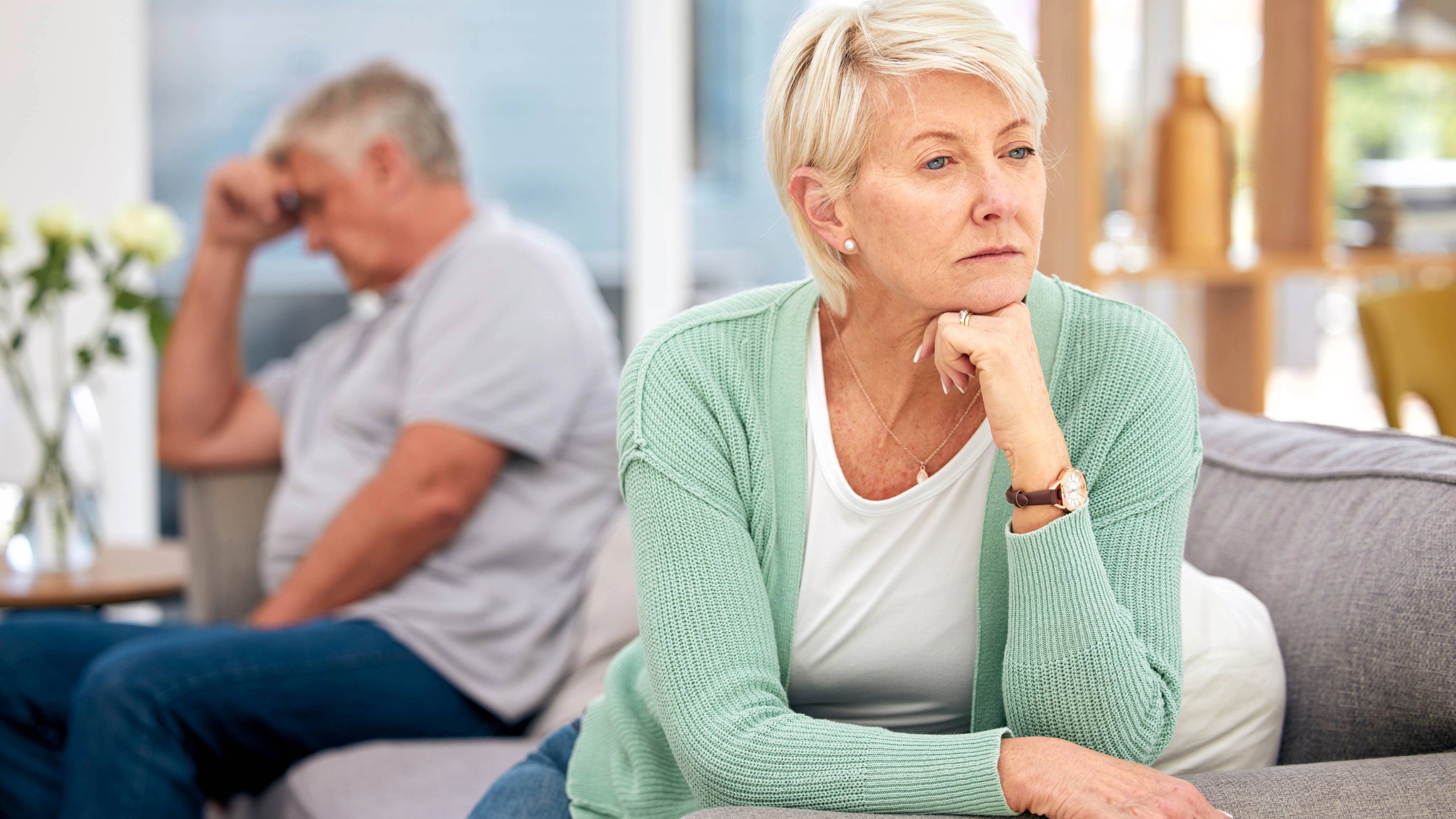 Mature couple on sofa thinking after a fight