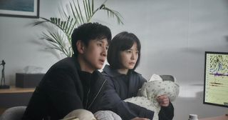 A couple (Lee Sun-kyun and Jung Yu-mi, who's holding a baby) sit in a medical office, in 'Sleep.'