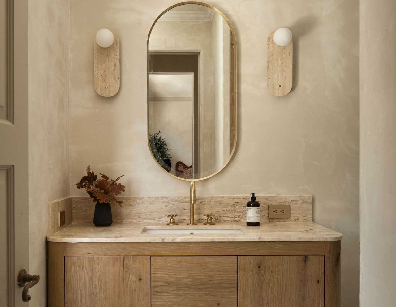 A bathroom with limewash walls and wall lights