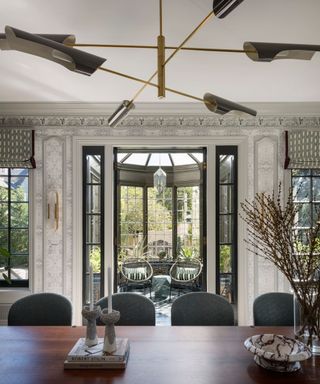 dining room with wooden table and black chairs and sun room behind