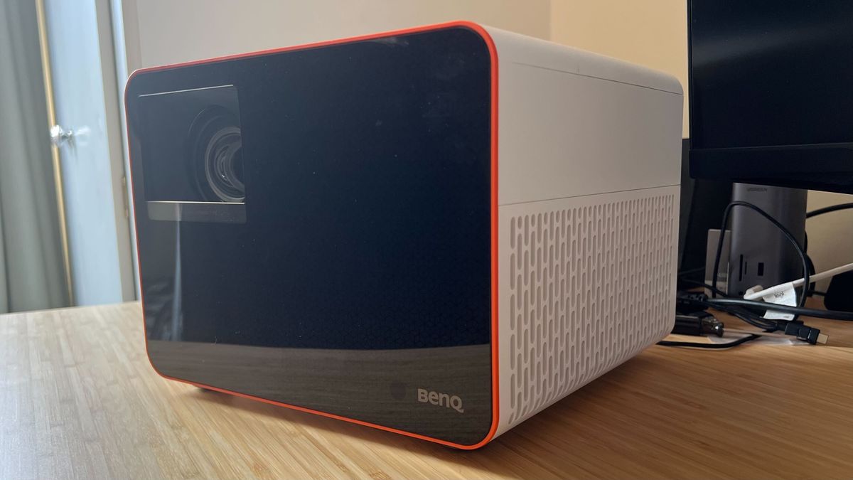 BenQ X3100i projector positioned on a wooden desk