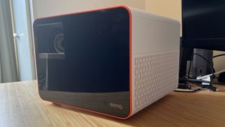 BenQ X3100i projector positioned on a wooden desk