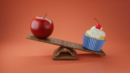 An apple and a cupcake on a seesaw, with the cupcake outweighing the apple.