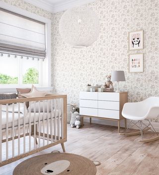 nursery with grey and white patterned wallpaper and wooden cot