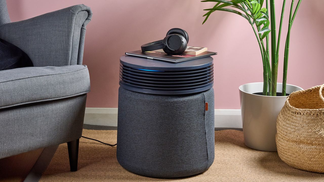 Some books and a pair of headphones have been placed on top of the Blueair Blue Signature air purifier.