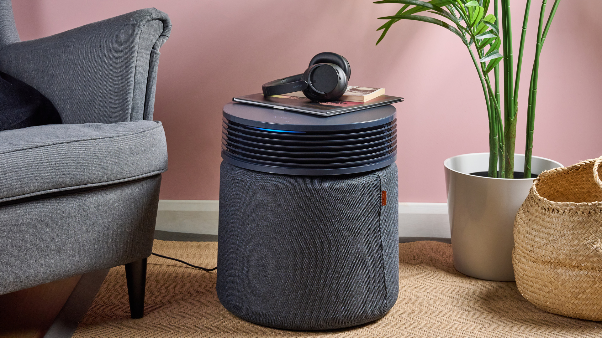 Some books and a pair of headphones have been placed on top of the Blueair Blue Signature air purifier.