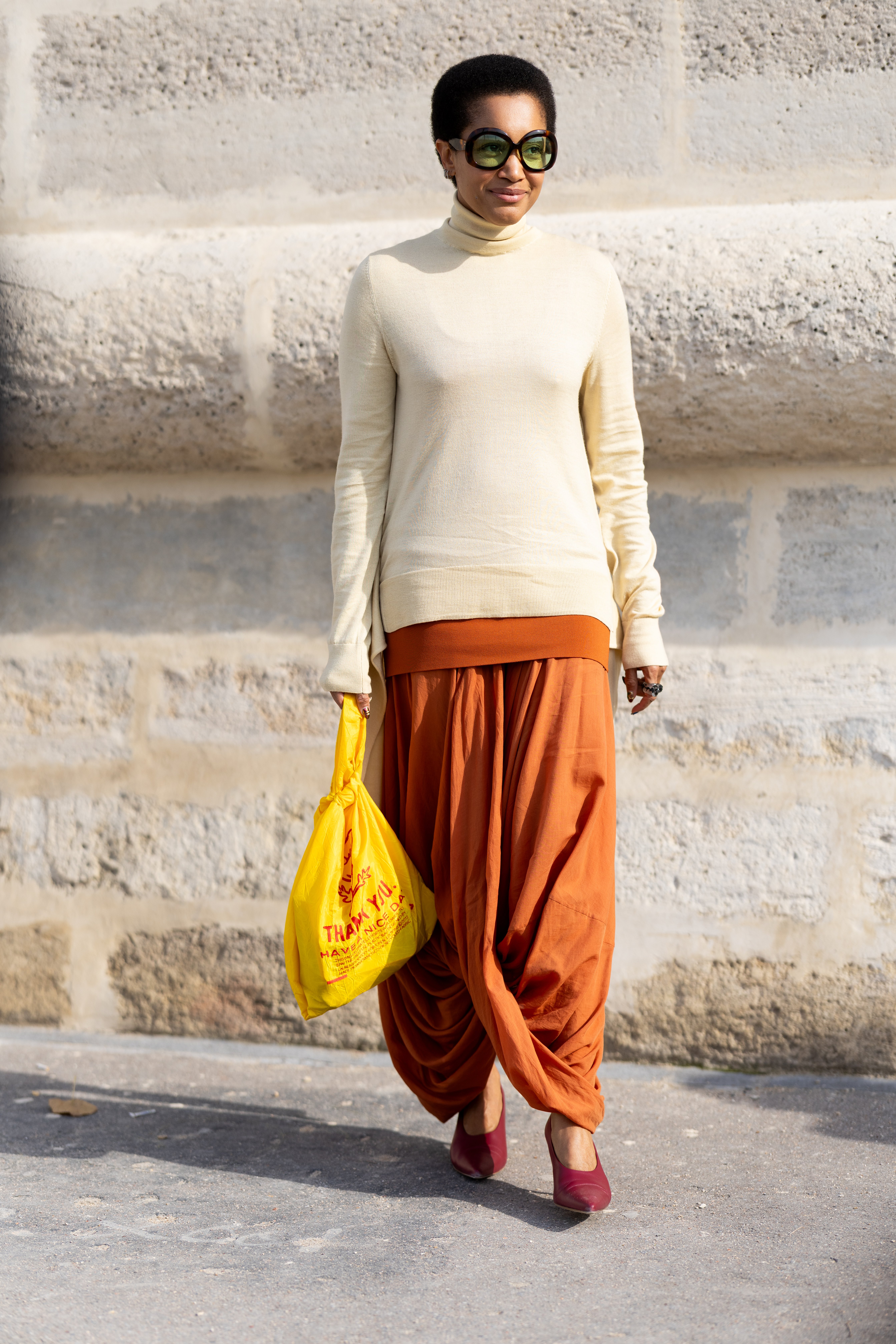 PARIS, FRANCE - OCTOBER 01: Tamu McPherson wears brown sunglasses, a light yellow turtle neck sweater, orange trousers and red leather pumps outside Dior show during the Womenswear Spring Summer 2026 as part of Paris Fashion Week on October 01, 2025 in Paris, France. (Photo by Valentina Frugiuele/Getty Images)