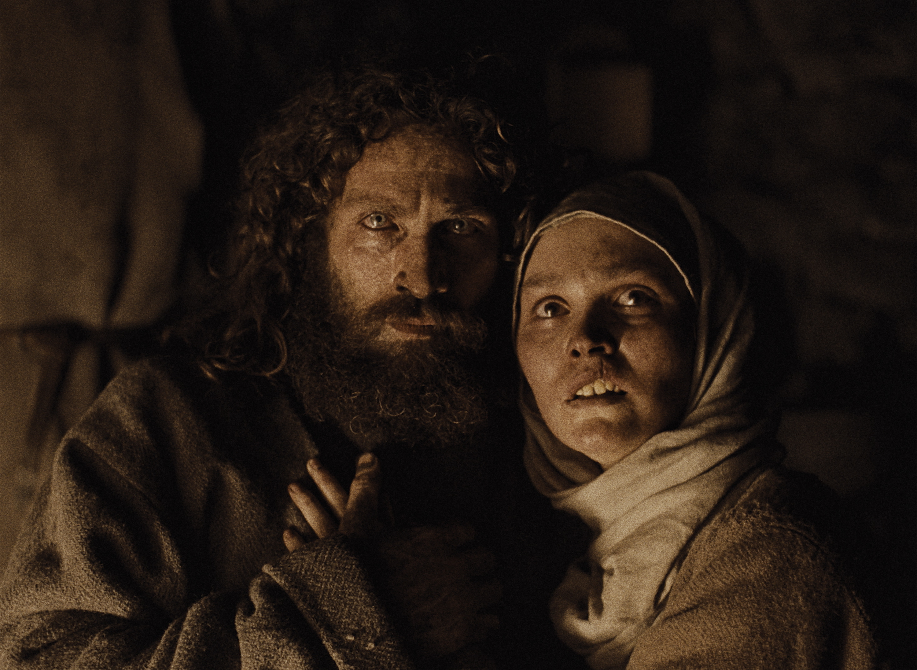 aaron taylor johnson and lily rose depp embrace in medieval garb in a dark image from the robert eggers film wewolf