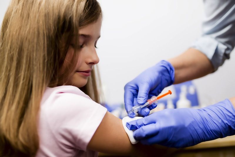 A girl receives a vaccine.