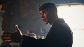 Cillian Murphy as Thomas Shelby has his hands raised emphatically as he talks to someone off camera in Peaky Blinders