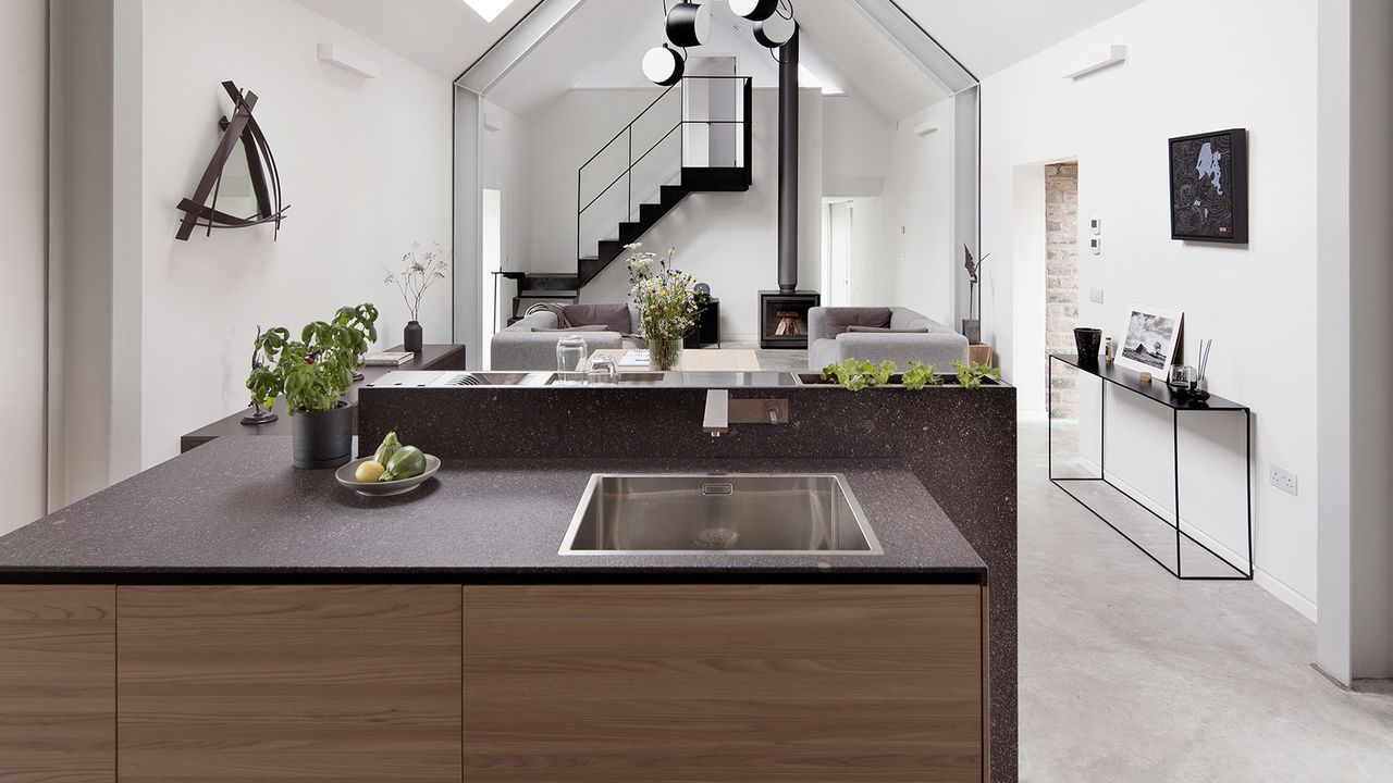 an architectural home with a wood and stone kitchen, and a living room with a stove in the background