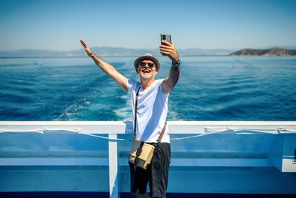 Man taking a photo with his cell phone on a cruise ship