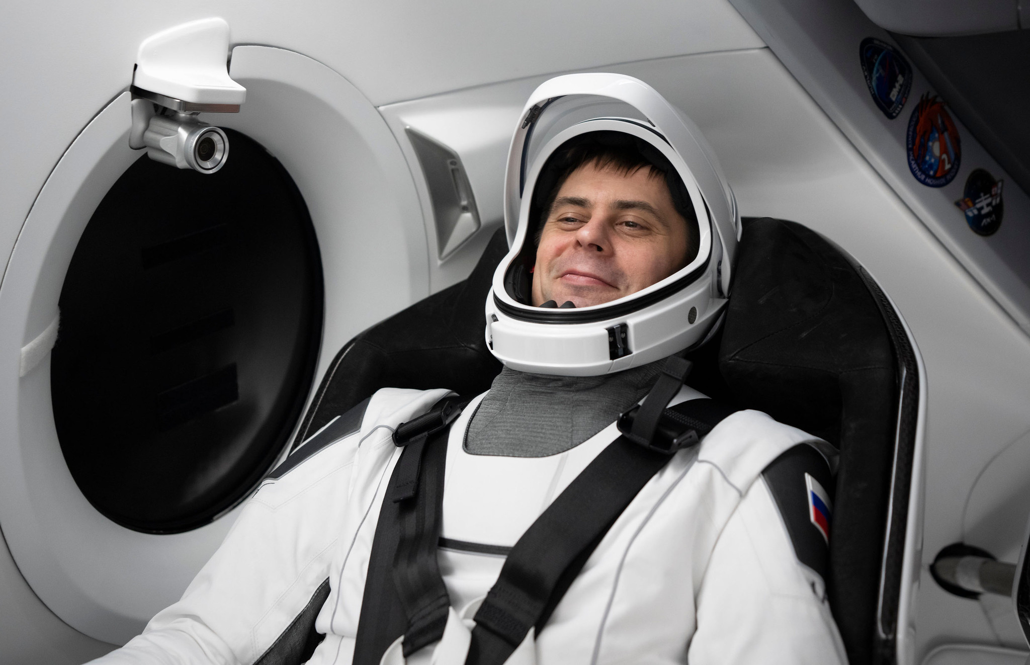 Roscosmos cosmonaut Andrey Fedyaev sitting in a spacecraft with seatbelt on