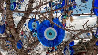 Amulets which offer protection against the evil eye hanging on a tree in the Cappadocia region, Nevsehir, Turkey