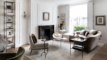 Which is the best white paint? Living room decorated with white walls, wooden flooring, large cream rug, L shaped sofa and armchair beside circular coffee table.