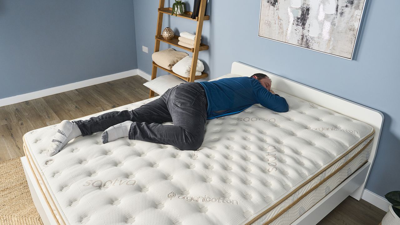 Simon, a man of average weight and height, sleeps on his stomach on the Saatva Classic during a pressure relief test