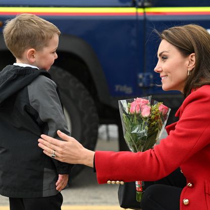 Britain's Catherine, Princess of Wales reacts as she is presented with a posy of flowers by four-year-old Theo Crompton during a visit to the RNLI (Royal National Lifeboat Institution) Holyhead Lifeboat Station in Anglesey, north west Wales on September 27, 2022.