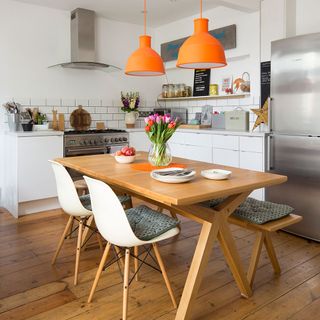 white kitchen with wooden flooring and table