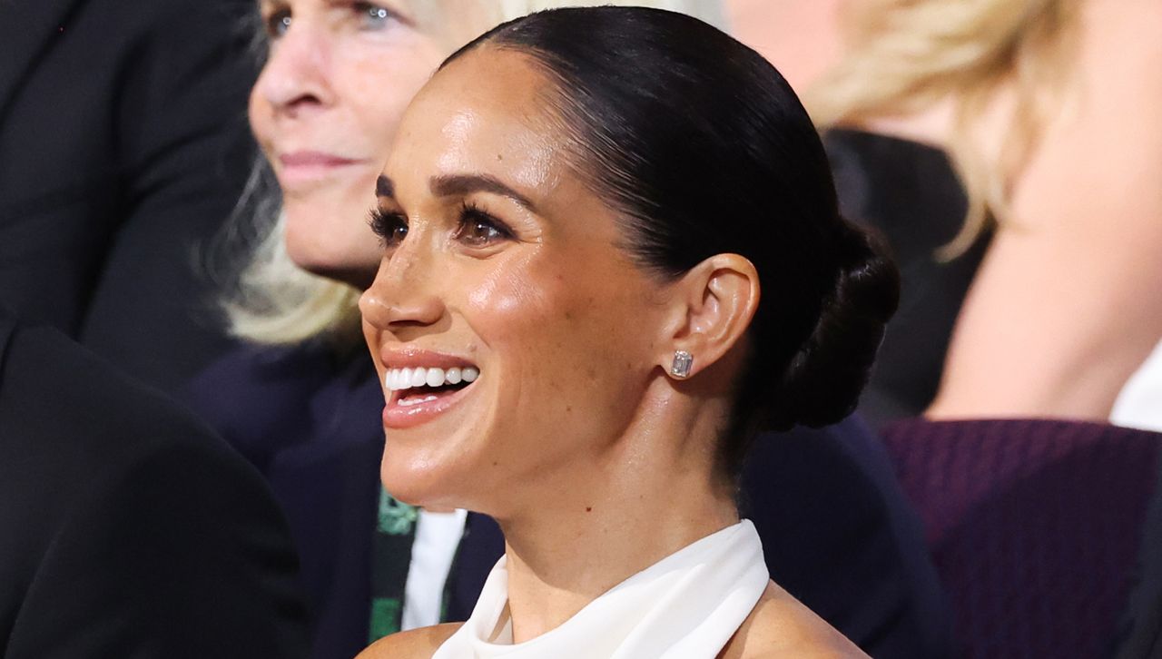 Meghan Markle attends the ESPY awards wearing a slicked back bun and a white halter top similar to the classic design she wears on her CBS sunday morning interview