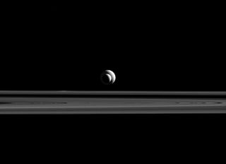 Saturn's moons Enceladus and Tethys line up above Saturn's rings in this 2015 photo from the Cassini spacecraft, which has been exploring Saturn's system since 2004.