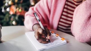 woman writing down her new year's resolutions