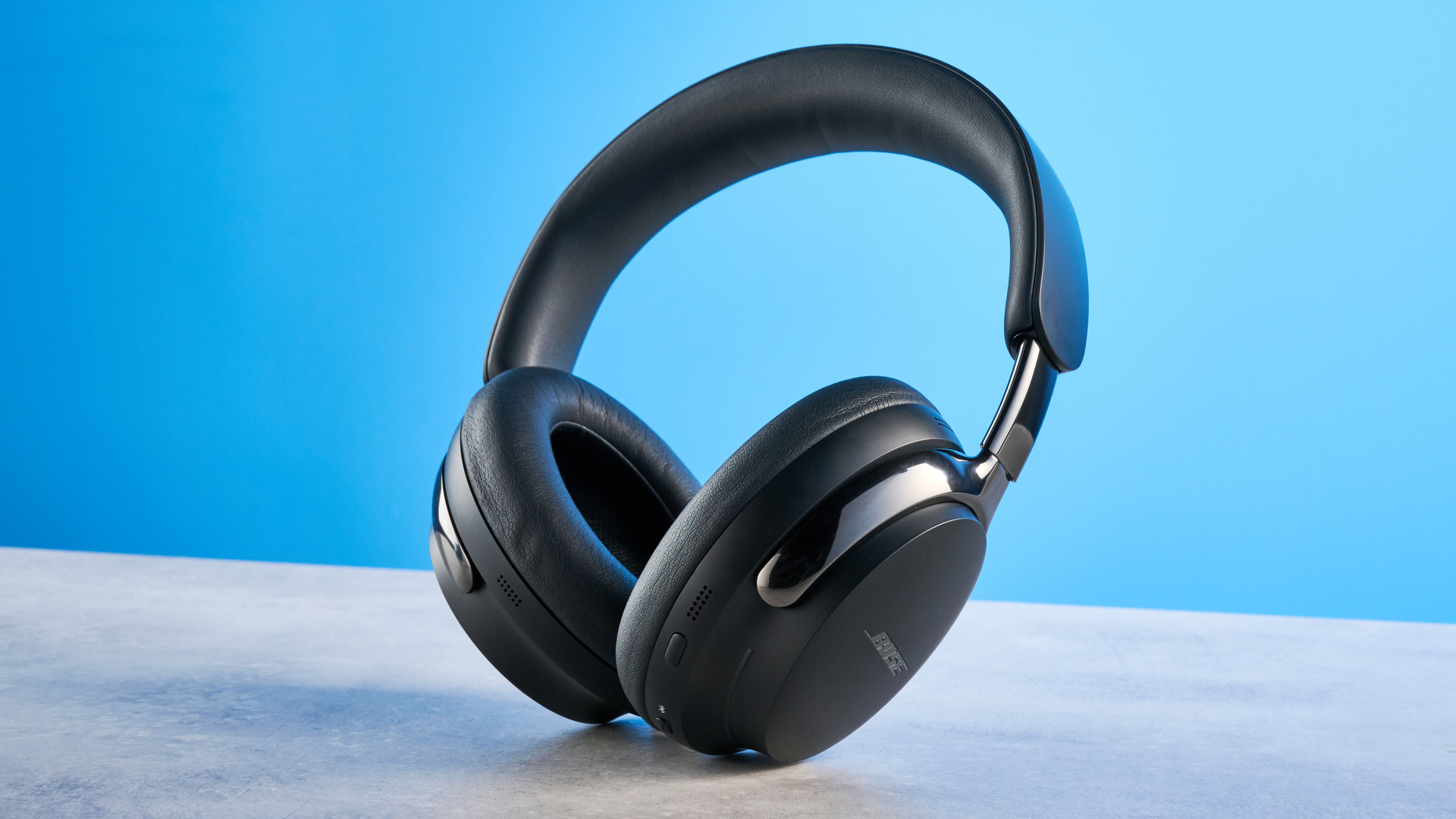 the bose quietcomfort ultra gen 2 headphones in black photographed on a blue tom's guide background
