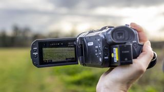 The Canon XA75 camcorder being handheld with the LCD screen pulled out