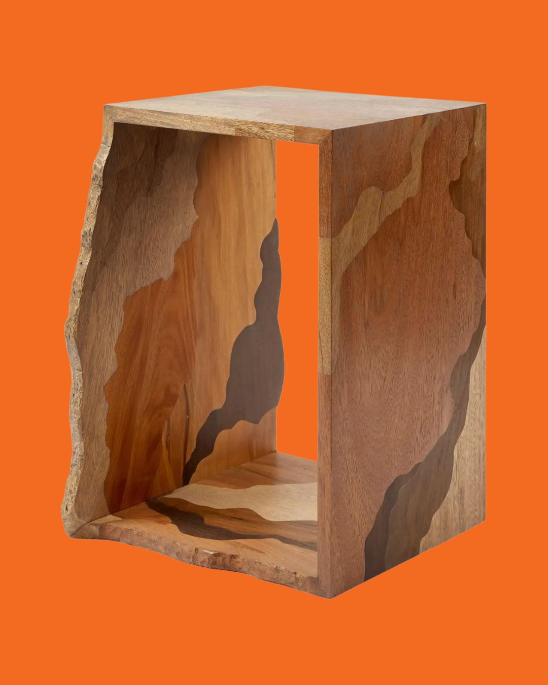 An organically shaped, hole wooden stool with a textured, multicolor wooden surface, standing against an orange background.