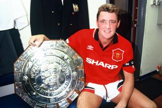 Manchester United defender Steve Bruce celebrates with the Charity Shield in 1994.