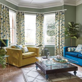 living room with green walls and floral curtains