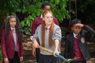 Summer Violet Bird plays Tonya Walters in Waterloo Road standing in a garden holding a spade with a bone on it.