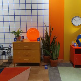 The Caliban XL globe lamp in orange at the Habitat spring/summer 2025 press showcase displayed on a yellow metal chest of drawers