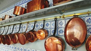 copper pans hanging on a wall