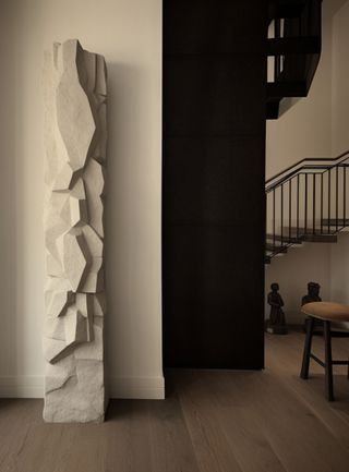 A white textural sculpture in a modern, minimalist room