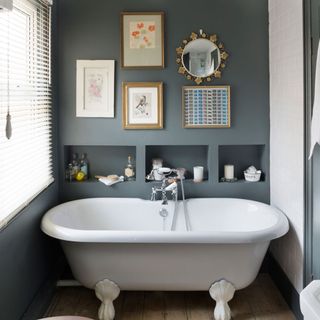 bathroom with grey wall and bathtub and picture frame and mirror