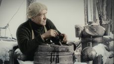 A man wears a beanie on a snow covered ship