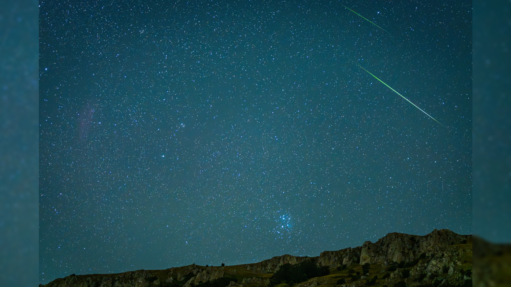 a streak of light crosses through the night sky