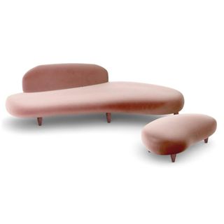 A pink curved velvet sofa