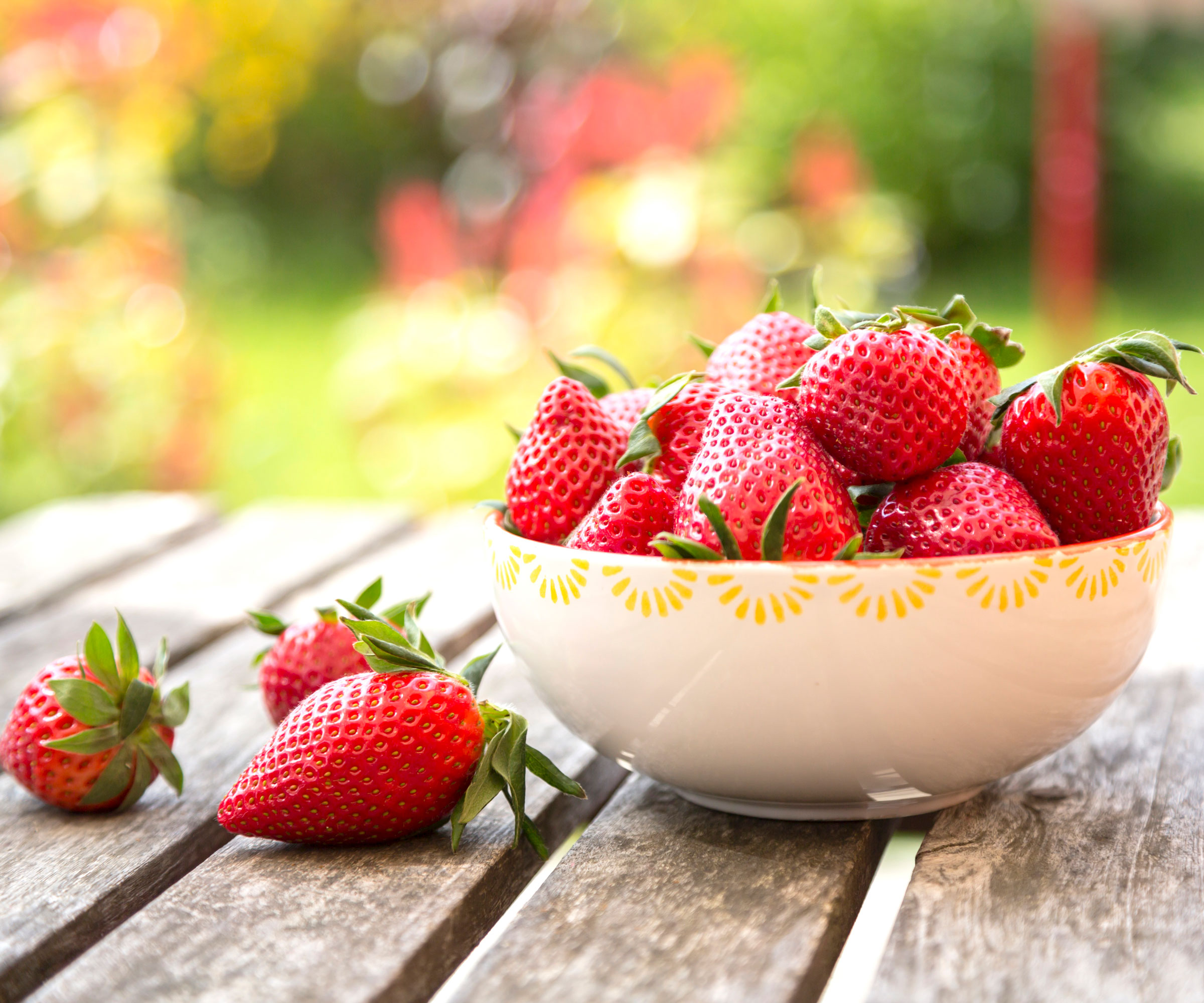 strawberries in ceramic dish on wooden table