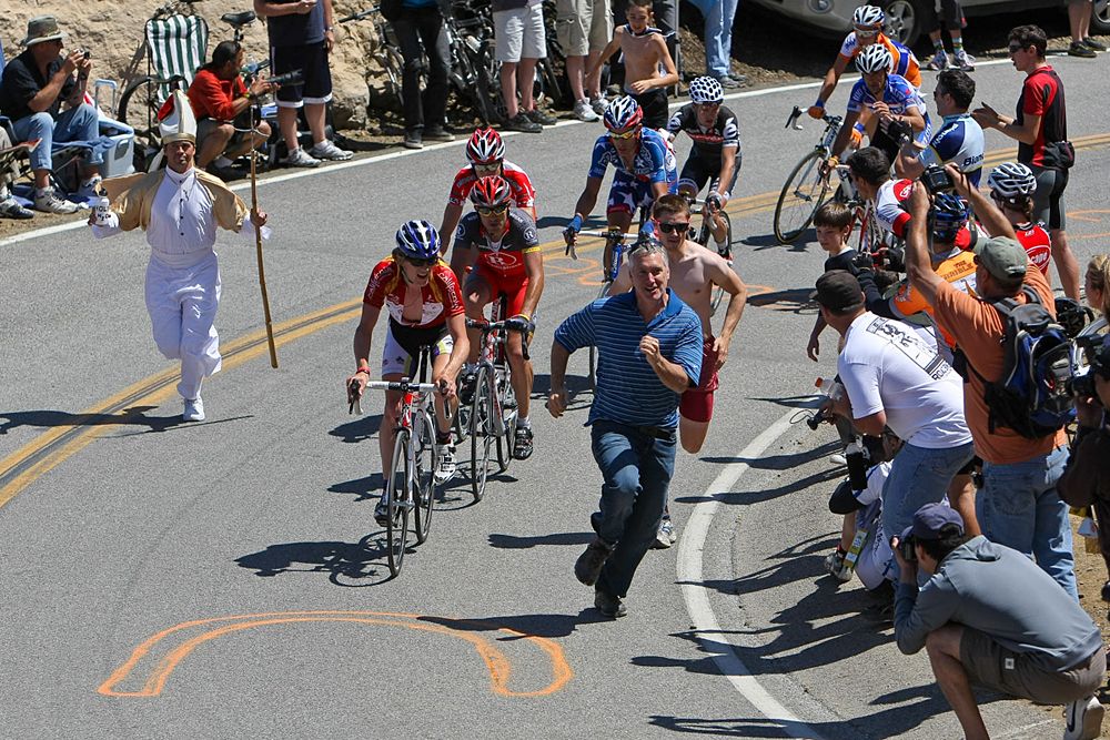Fans race riders along the climb