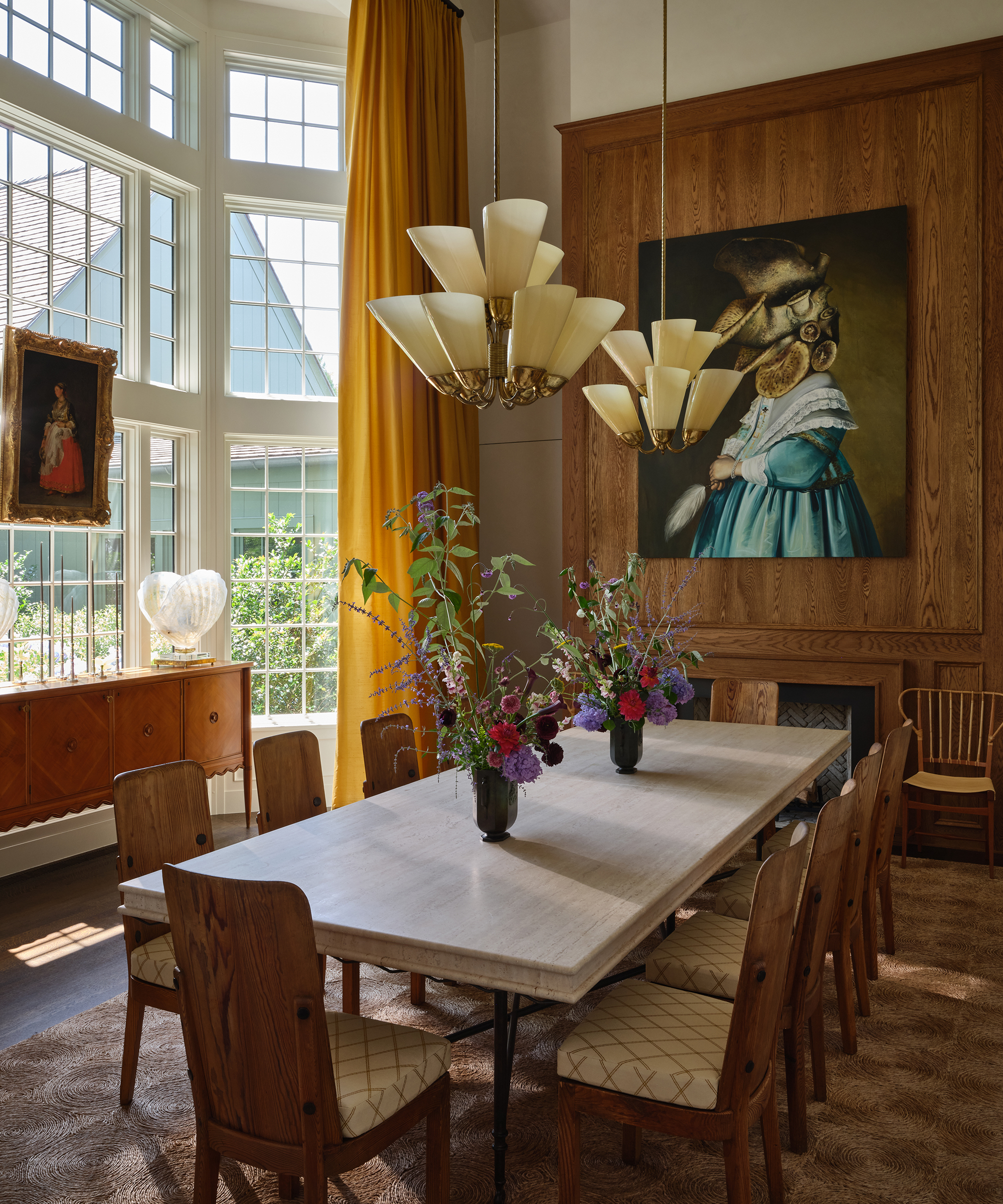 dining room with large wood table and wood chairs with a modern art print hanging on the wall above it