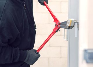 A thief cutting a lock to break into a building