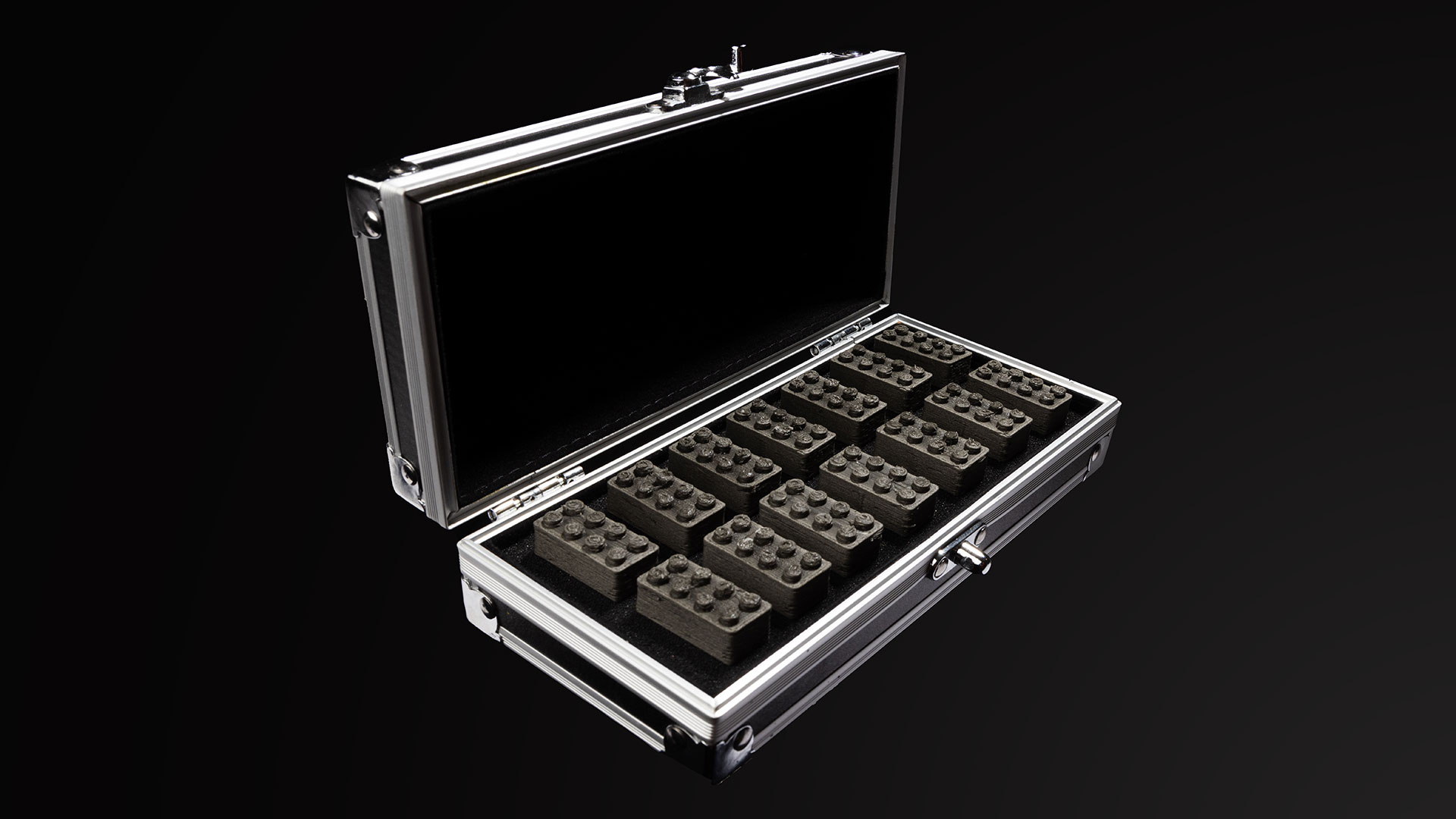 A black striped suitcase filled with 14 gray bricks sits on a black background
