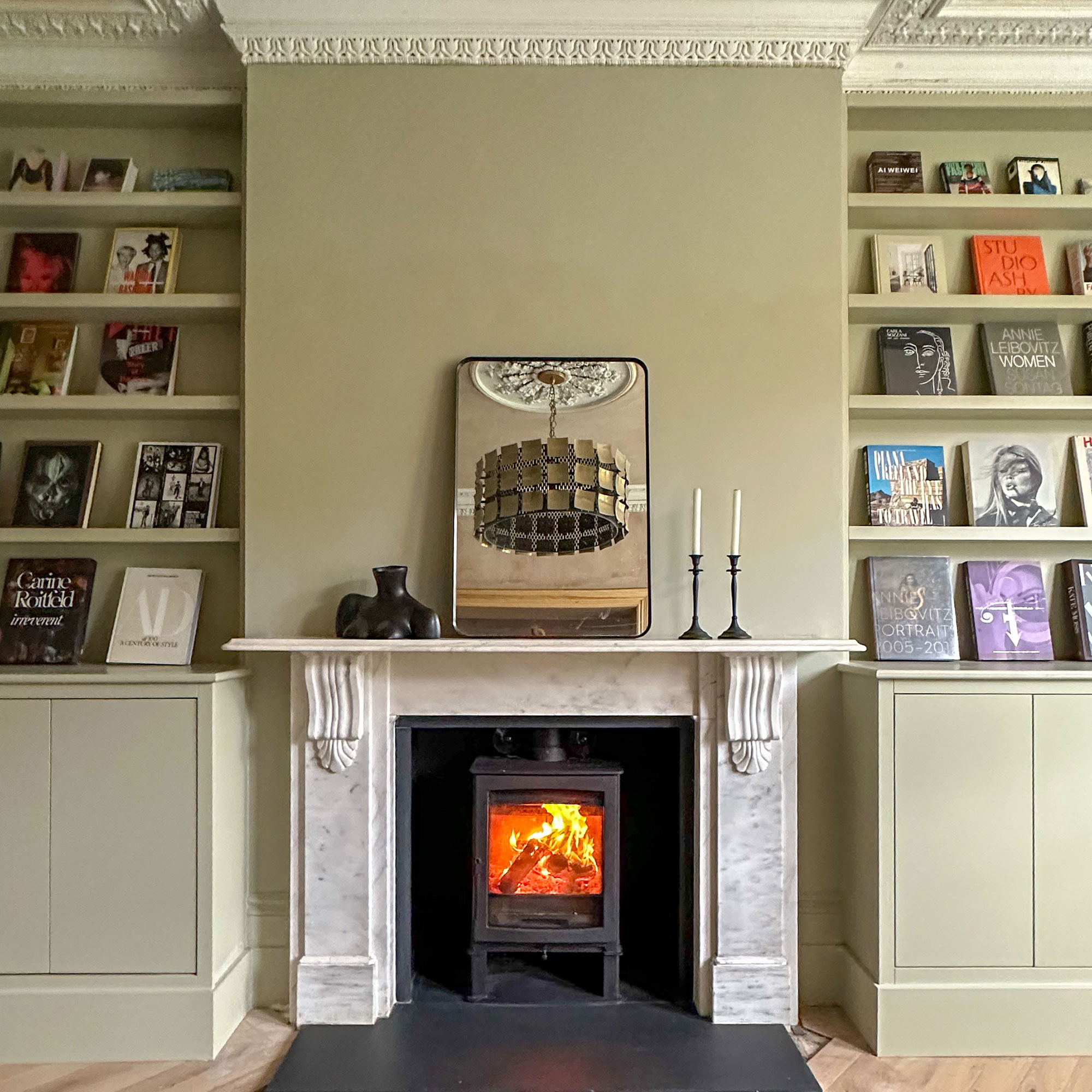 Living room with built in bookshelves on either side of marble fireplace