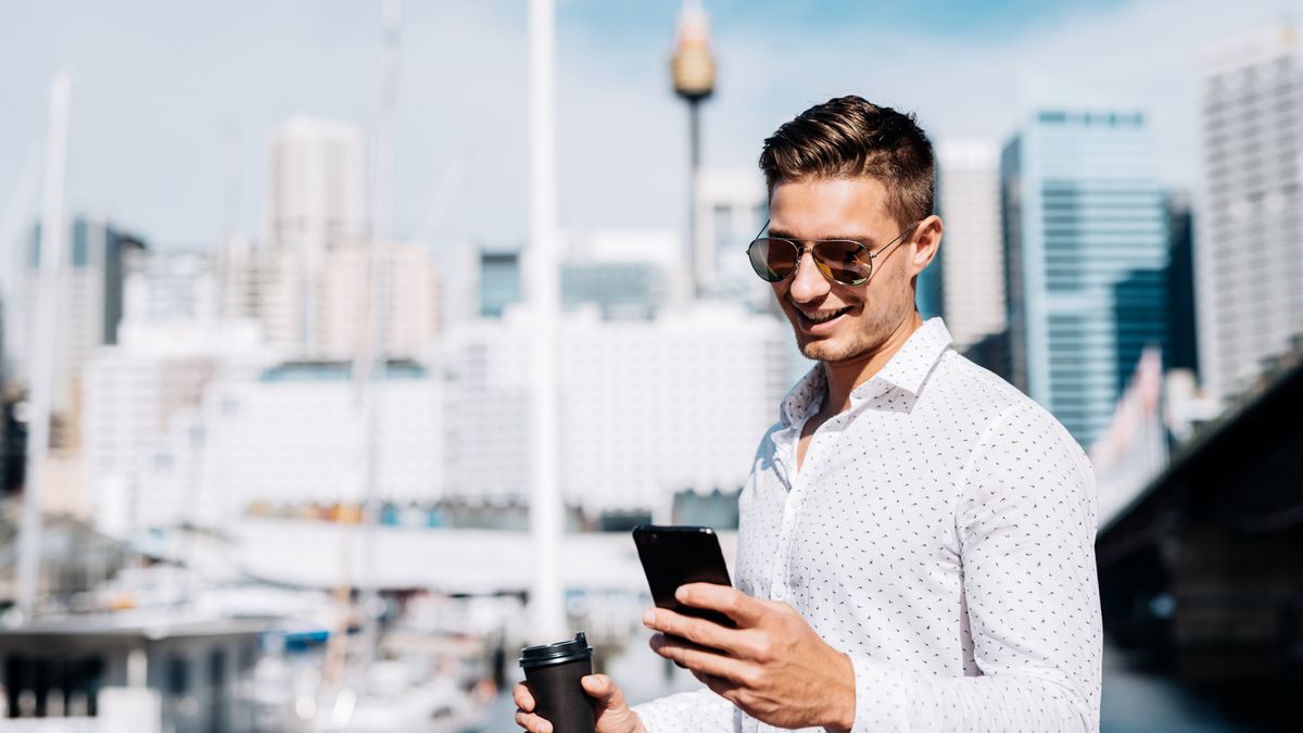 Man using smartphone with Sydney Westfield Tower in background