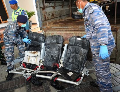 Personnel from the Indonesian Navy display recovered parts of the plane