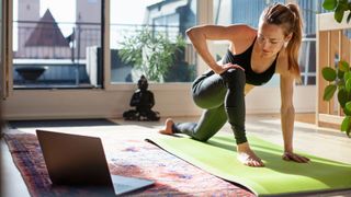 Woman stretching and doing yoga in her living room to avoid making the most common running mistakes