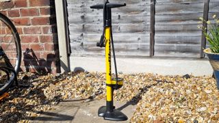 The Topeak JoeBlow Sport III in a sunny gravel courtyard in front of a fence